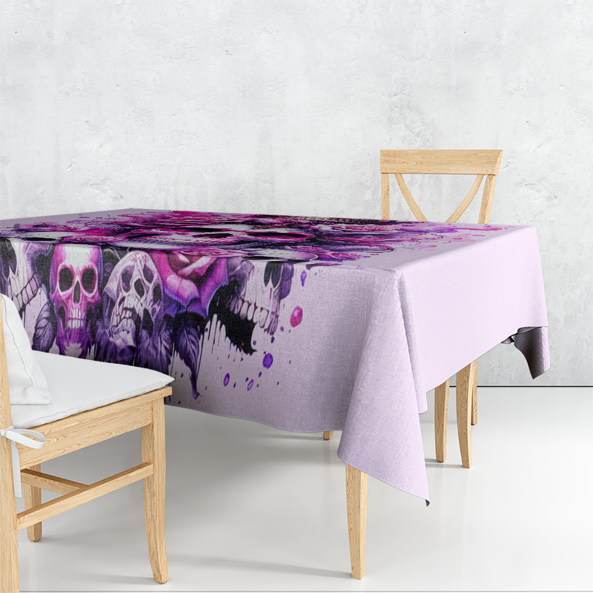 Pink skull tablecloth draped over table with purple skull and rose splash print