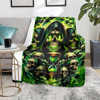 Skull and hourglass flame blanket in vivid green, folded on living room chair