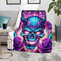 Skull graphic throw blanket with purple roses and teal flame accents, folded on a living room rug