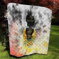 Quilt blanket with diamond stitching, black silhouette in center, and sunflower floral bouquet