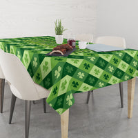 Green clover-pattern tablecloth on dining table with serving items