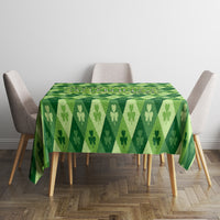 Green clover-pattern tablecloth on square table with chairs