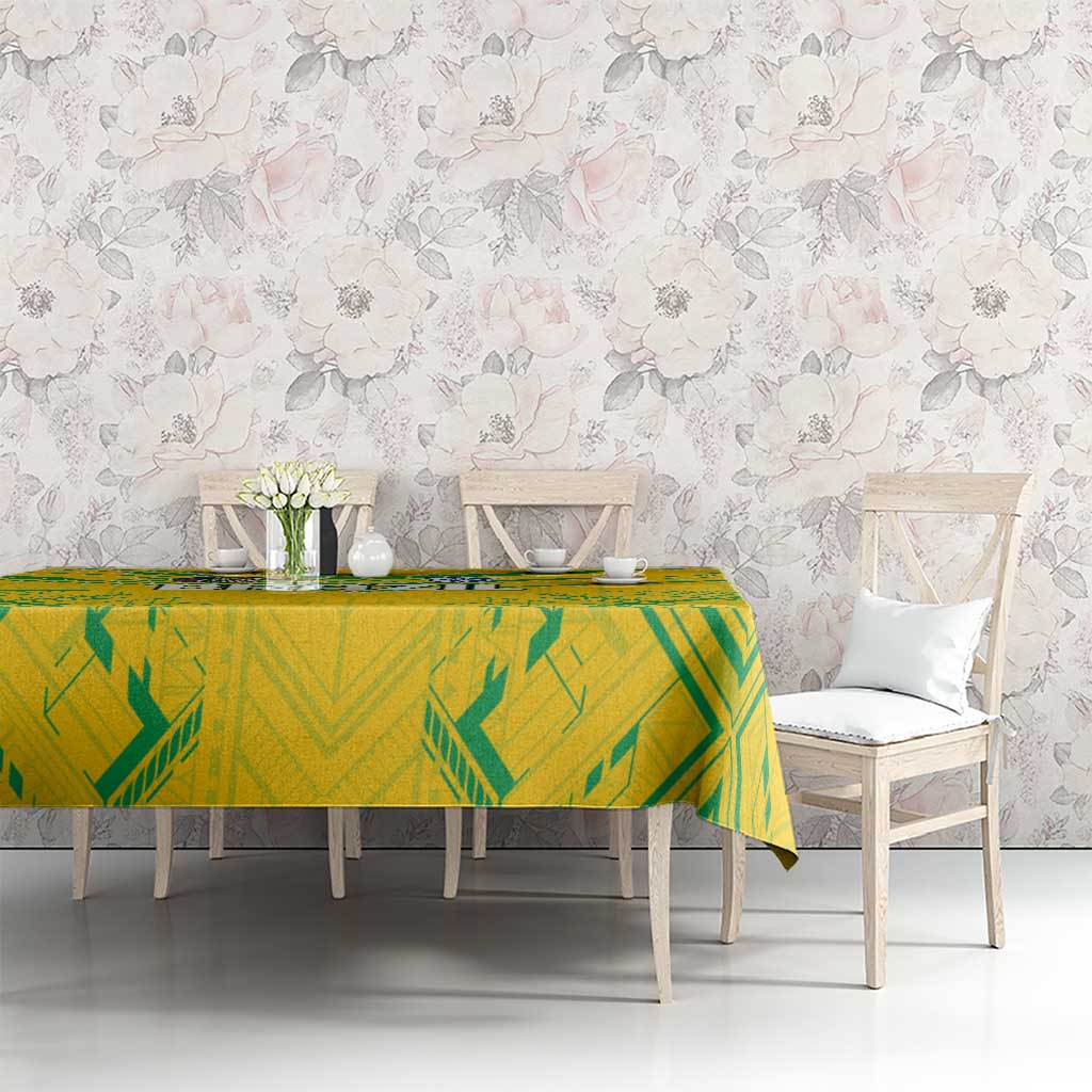 Yellow tablecloth with green geometric pattern on a long table beside chairs