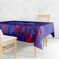 Blue football-themed tablecloth with red abstract pattern, draped over wooden dining table