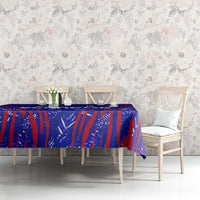 Blue tablecloth with red patterned design on dining table with chairs and pillows