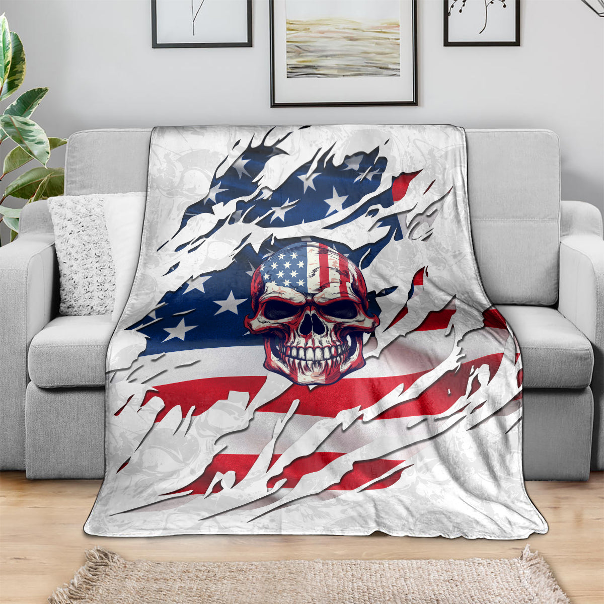 American flag skull print blanket draped over gray sofa, white base with blue stars and red stripes