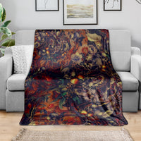 Red skull art blanket draped on a sofa, showing skulls and colorful botanical motifs