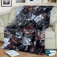 Dark floral skull and snake throw blanket with roses, white flowers, and serpent artwork on couch
