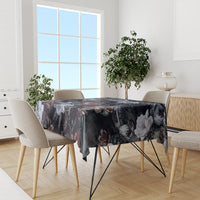 Dark patterned tablecloth with roses and serpent motifs on dining table
