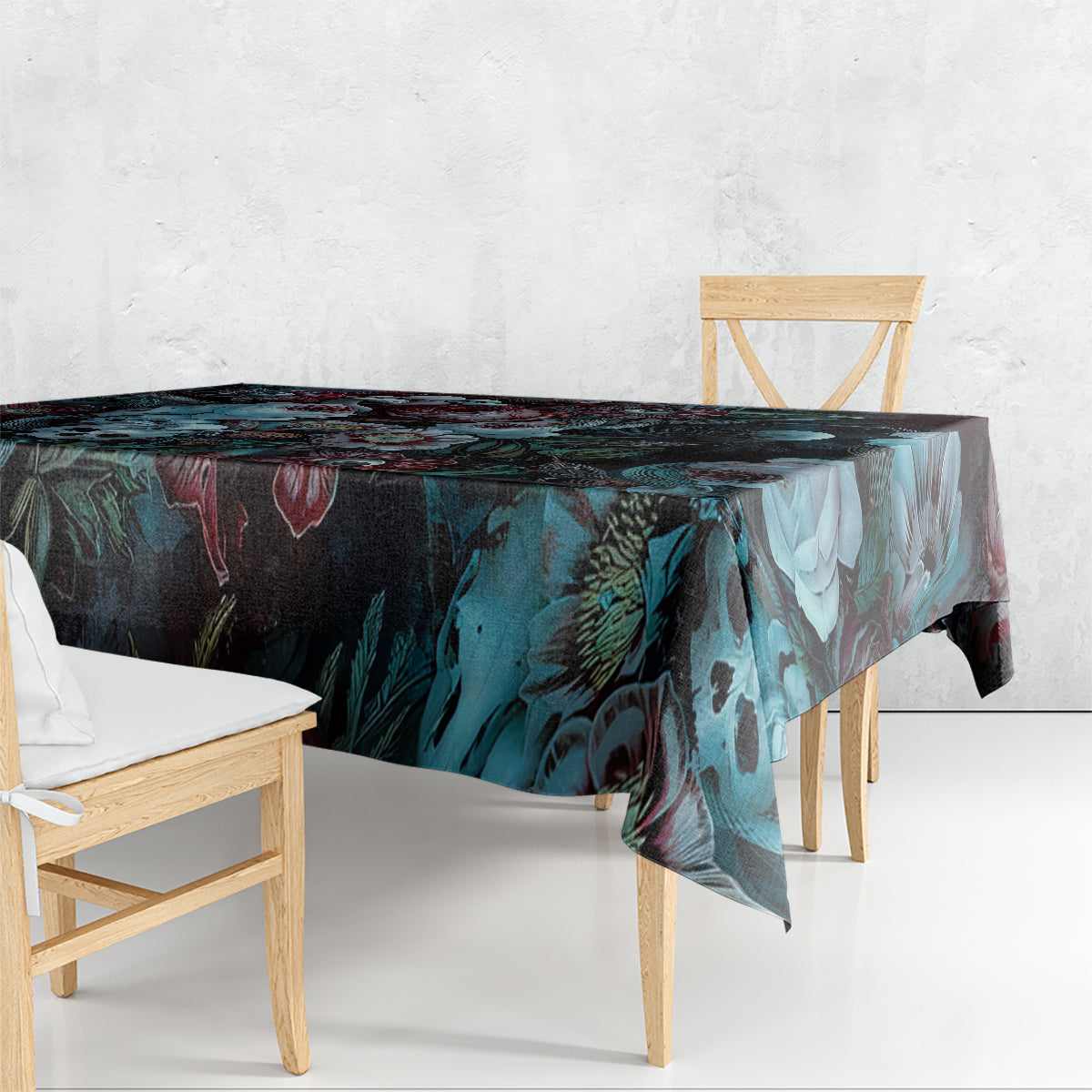 Dark floral tablecloth with teal-blue leaves and skull-and-rose print, draped corner
