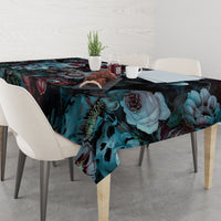 Dark floral tablecloth with detailed roses, teal leaves, and skull motifs, corner view