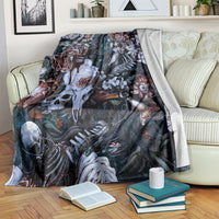 Skull and rose nightmare blanket draped over sofa, dark teal fabric with white skeletal imagery.