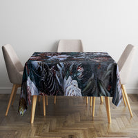 Black tablecloth with skull and flower artwork, square over dining table