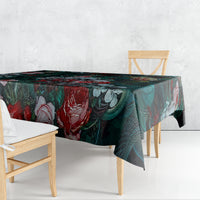 Green floral tablecloth draped over table edge with bold rose and leaf pattern