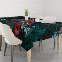 Green patterned tablecloth with red roses and teal leaves, covering dining table
