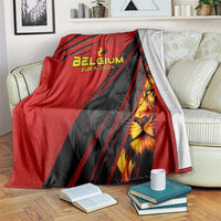 Red and black Belgium football blanket draped over couch, showing lion crest graphic