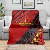 Red and black Belgium football blanket spread across a grey sofa with crest