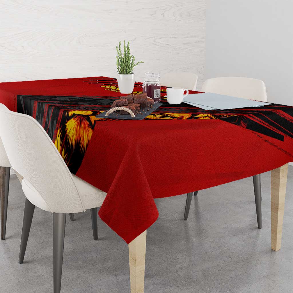 Red tablecloth with black pattern and lion graphic over dining table