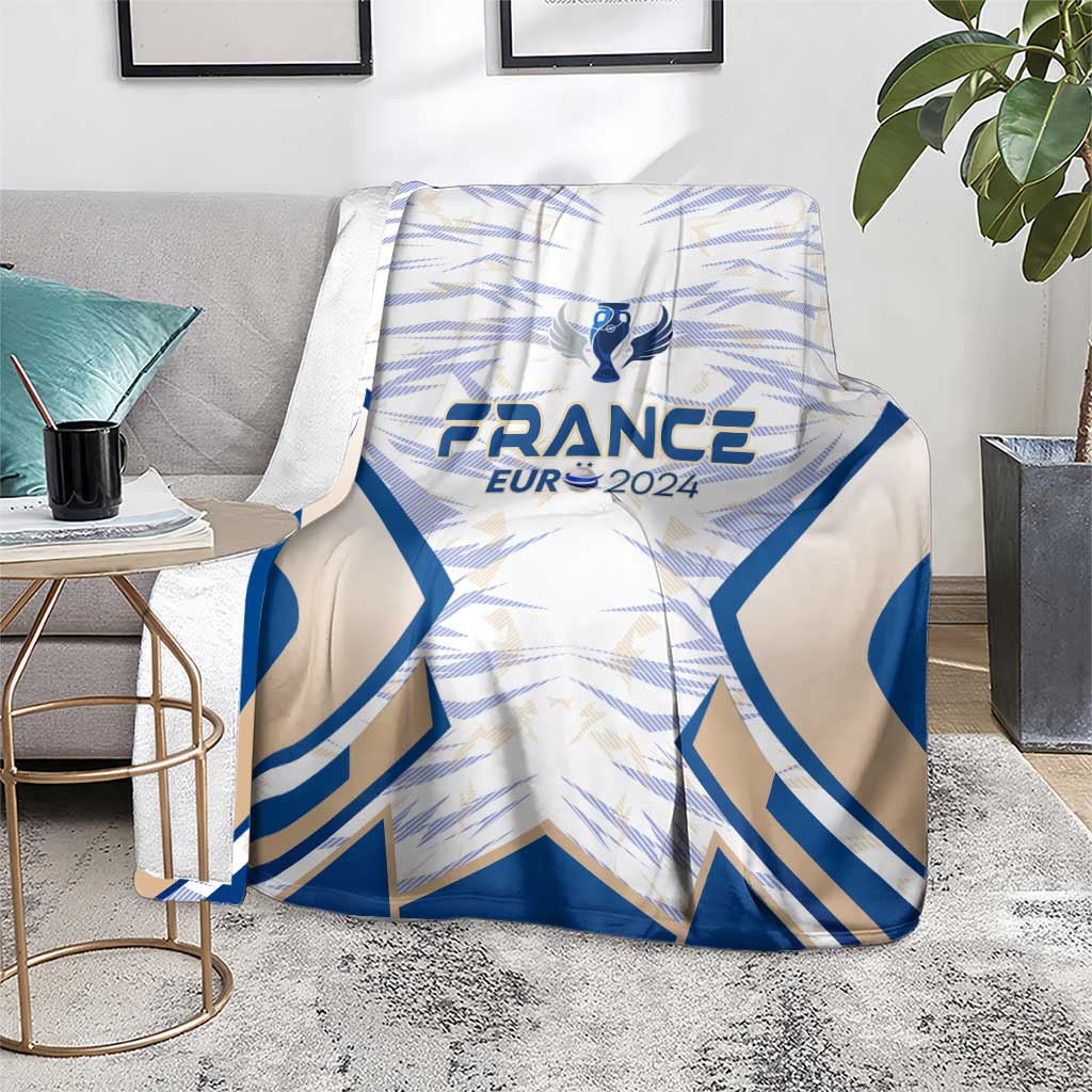 France football blanket, blue wing pattern with France Eur 2024 crest, on gray couch