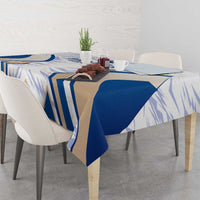 Dining table with blue-and-white France-themed tablecloth and folded over corners