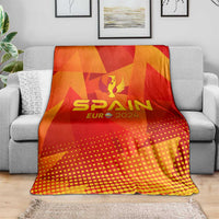 Spain football blanket on couch, red-orange geometric print with SPAIN EURO 2024 trophy