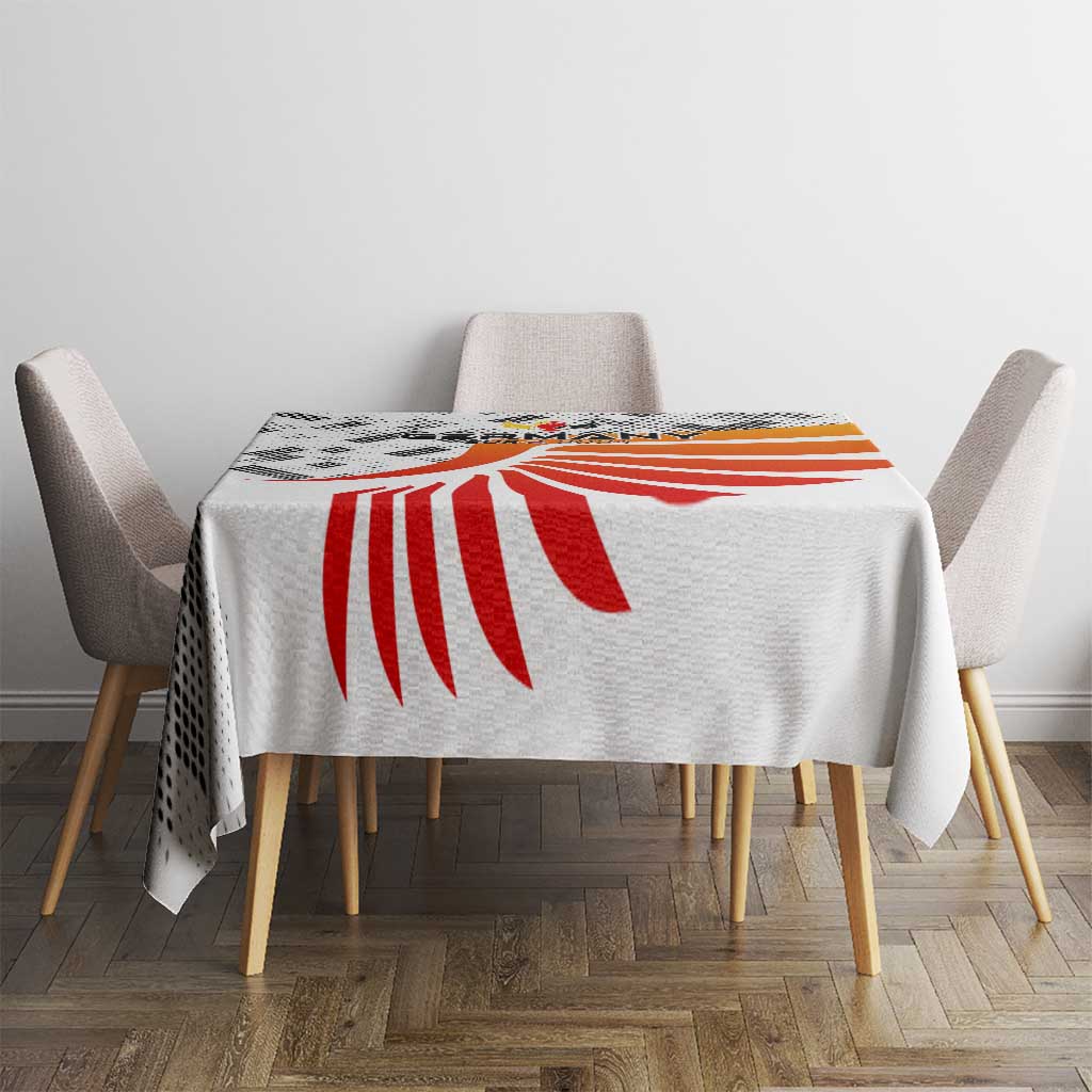 White tablecloth with red-orange wing motif centered, draped over dining table