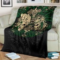 Black throw blanket with green Aztec warrior skull graphic, draped on a chair