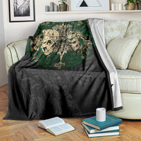 Black and green Aztec warrior skull blanket draped over a bed