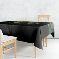 Black tablecloth with green Aztec skull warrior print draped over table edge