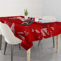 Red printed tablecloth covering dining table with repeating wing-and-star motif