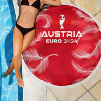 Red round beach blanket with white fringe and Austria Euro 2024 graphic beside pool