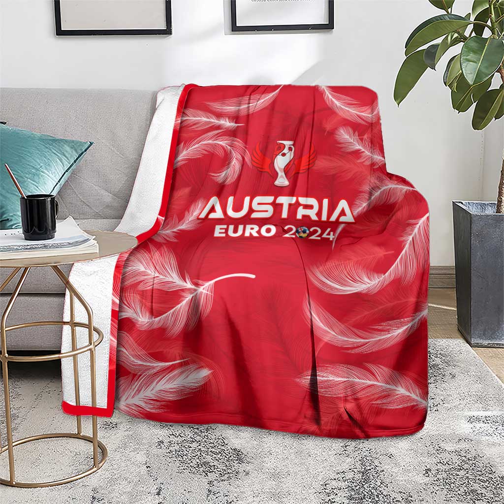 Red Austria Euro 2024 blanket draped on a sofa with white feather pattern