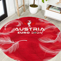 Red round trophy-style carpet with Austria Euro 2024 graphic and feather pattern