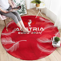 Red round Austria Euro 2024 carpet with trophy emblem and white feather motifs
