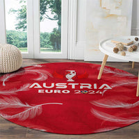 Red round Austria Euro 2024 carpet with central trophy logo and flowing feather lines