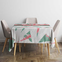 White round-edge tablecloth with green and red graphic print on dining table