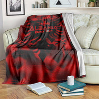 Red and black Albania football blanket draped over sofa, eagle crest and EURO 2024