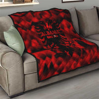 Red quilt throw on sofa with black Albania EURO 2024 logo and pattern