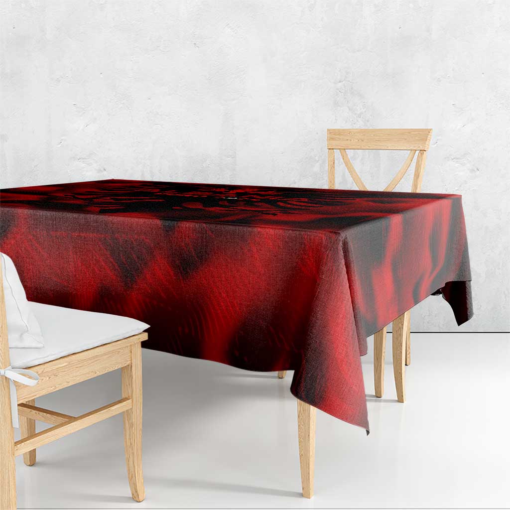 Red tablecloth with black swirling wing pattern, hanging over the table edge