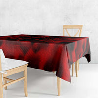 Red tablecloth with black swirling wing pattern, hanging over the table edge