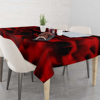 Red tablecloth with black wing pattern, draped over a dining table centerpiece