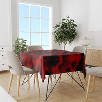 Red tablecloth with black abstract wing-style pattern, draped over a table
