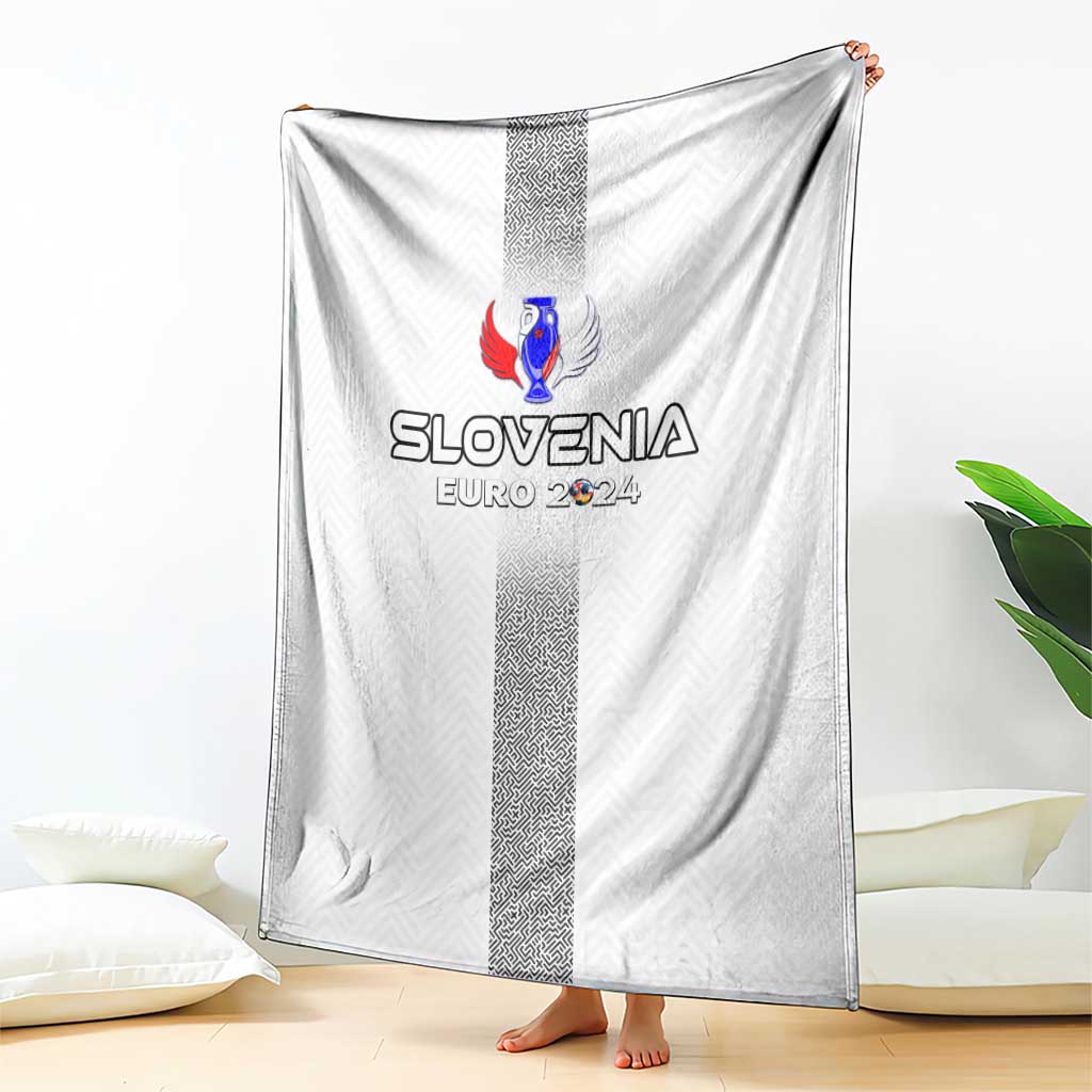 White throw blanket draped on floor with Slovenia crest and dark vertical stripe