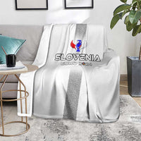White Slovenia blanket on sofa, dark vertical stripe and crest logo centered