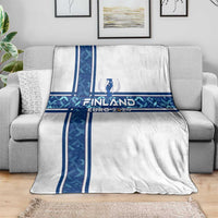 White blanket draped on sofa with blue Finland cross design and Euro 2024 lettering