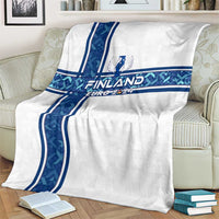 White blanket on couch with blue Finland cross stripes and Euro 2024 logo