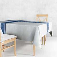 White tablecloth with blue border and trophy-wing style design on tabletop