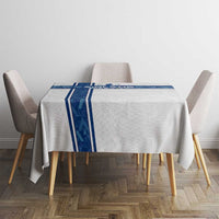 White tablecloth with blue stripe trim draped over a rectangular dining table