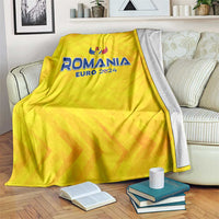 Yellow Romania Euro 2024 football blanket with wing trophy emblem, draped over sofa