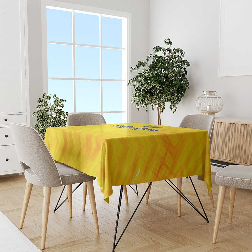 Yellow football tablecloth on dining table with crest logo, abstract pattern along edges